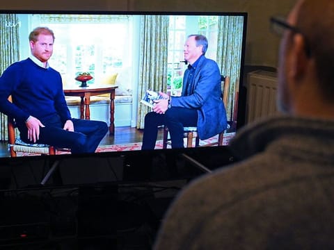   A member of the public poses in his front room in Manchester, north-west England, watching a television interview broadcast on ITV, being given by Britain's Prince Harry, Duke of Sussex on January 8, 2023, ahead of the publication of his book, 'Spare'. 