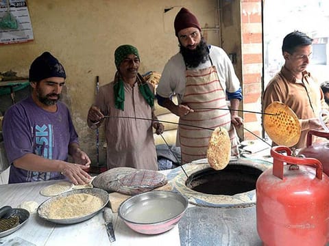 A vendor makes traditional bread (naan) in Lahore, Monday, January 9, 2023. 