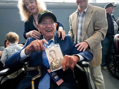 World War II veteran Joseph Eskenazi  holds a photo of his younger self.