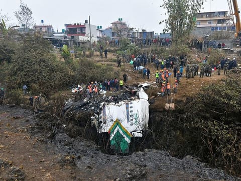 Rescuers inspect the wreckage at the site of a Yeti Airlines plane crash in Pokhara.