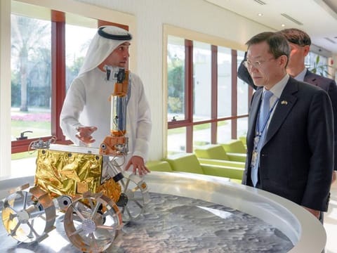 Salem AlMarri (left) showing a replica of Rashid Rover to Lee Jong-ho