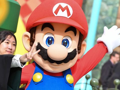 A guest takes a photo with Mario during a preview of Super Nintendo World at Universal Studios in Los Angeles, California.