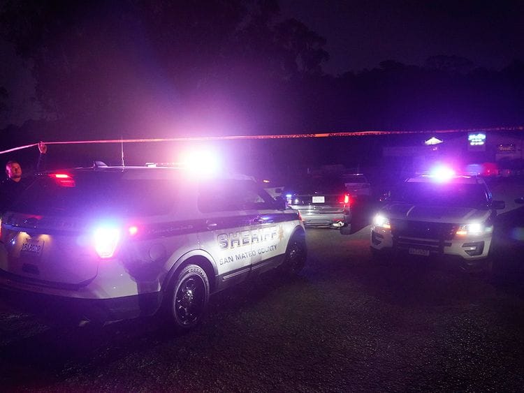 Law enforcement personnel control the scene of a shooting in Half Moon Bay, California.  