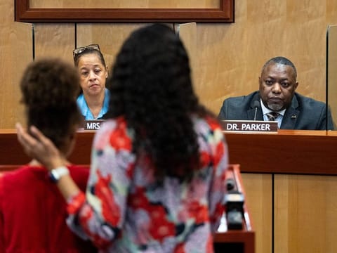 Djifa Lee, a second-grade teacher at Saunders Elementary, center, stands with her daughter as she speaks in front of the Newport News School Board at the Newport News Public Schools Administration building on Jan. 17, 2023, in Newport News, Va., following a shooting at Richneck Elementary by a six-year-old that left a teacher in critical condition. 