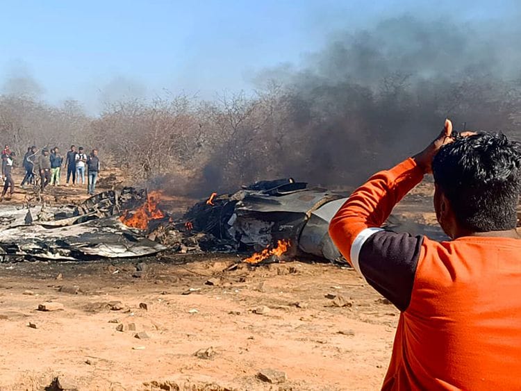 People gather near the wrecked remains after a Sukhoi-30 and Mirage 2000 aircraft