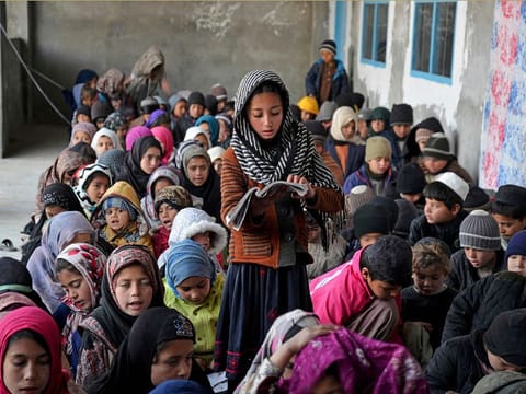 In this photograph taken on January 22, 2023, Afghan children take lessons at an open classroom in Dand district of Kandahar province. [Illustrative image]