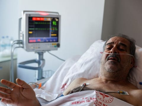 Huseyin Berber, 62, a survivor who was rescued after being trapped under the rubble for 187 hours in Antakya, speaks to media and doctors as he receives medical attention at Mersin City hospital, in the aftermath of a deadly earthquake, in Turkey, February 15, 2023.  