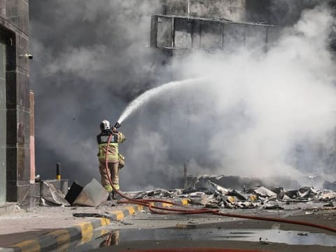 A fire fighter from Ajman Civil Defence battling a fire which broke out in a residential tower on Friday afternoon.