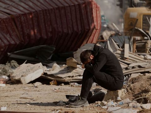 A man reacts as people search the rubble of collapsed apartment blocks for personal belongings, in the aftermath of a deadly earthquake, in Kahramanmaras, Turkey.