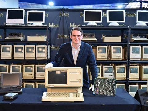 Erik Rosenblum, NFT Development Strategist at Julien's Auctions, poses behind the Apple Lisa, one of the first personal computers released in 1983 on display with motherboard.