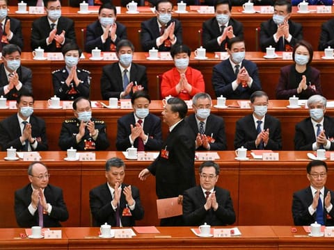 China's President Xi Jinping (centre) walks past delegates as he prepares to vote during the third plenary session of the National People's Congress (NPC) at the Great Hall of the People in Beijing on March 10, 2023.  