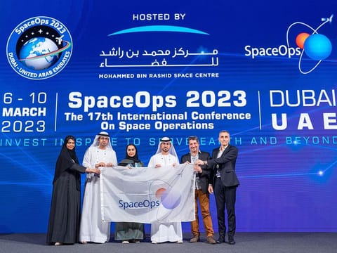 MBRSC hands over the SpaceOps flag to Gerard Gallet and Hubert Fraysse from CNES, the host of the next SpaceOps Workshop, during the closing ceremony in Dubai on Friday