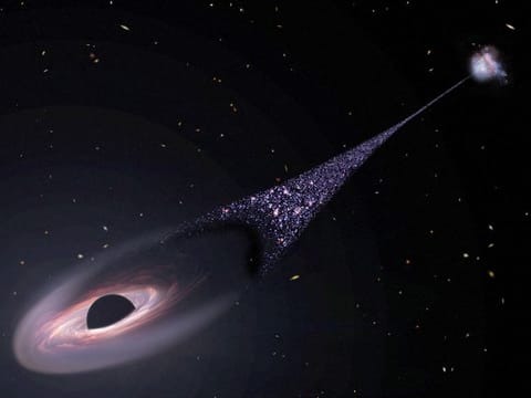 In this illustration released by NASA on April 7, 2023, an artist's impression depicts a runaway supermassive black hole that was ejected from its host galaxy as a result of a tussle between it and two other black holes. This illustration is based on Hubble Space Telescope observations of a 200,000-light-year-long "contrail" of stars behind an escaping black hole. 