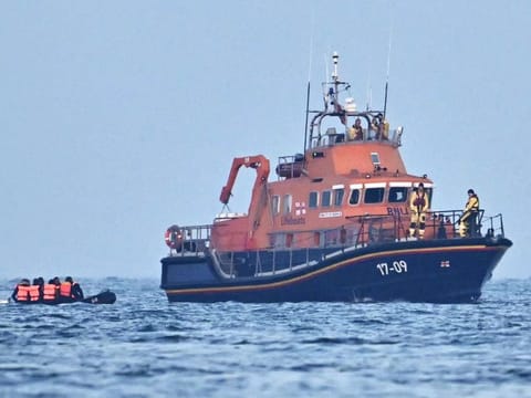 Crew aboard Royal National Lifeboat Institution (RNLI) Severn class lifeboat, the City of London II, pick up migrants in an inflatable boat who were travelling across the English Channel, bound for Dover on the south coast of England. - More than 45,000 migrants arrived in the UK last year by crossing the English Channel on small boats.  