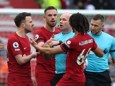 Liverpool's Andrew Robertson (left) reacts after appearing to be elbowed in the face by assistant referee Constantine Hatzidakis (right).