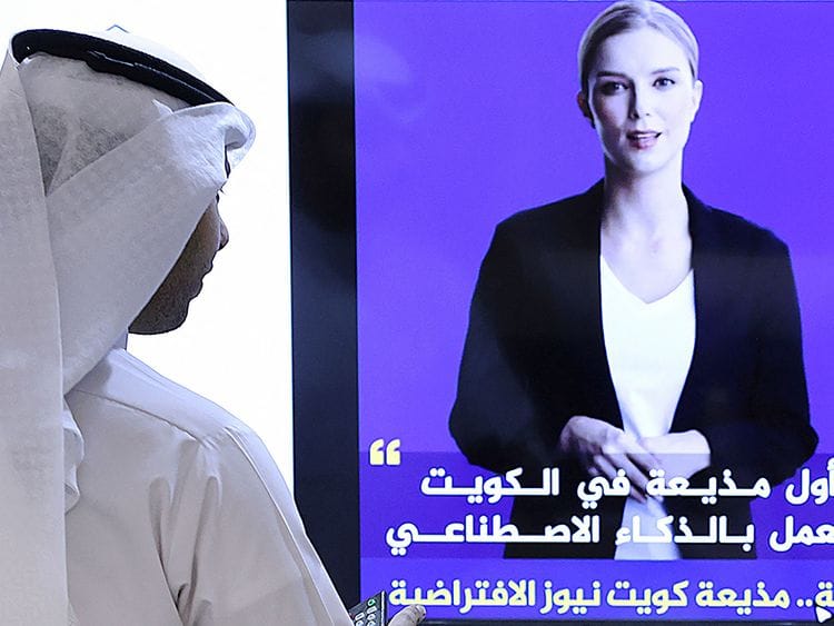 A journalist watches an introductory video by the 'artificial intelligence' anchor 'Fedha' on the twitter account of Kuwait News service, in Kuwait City.  