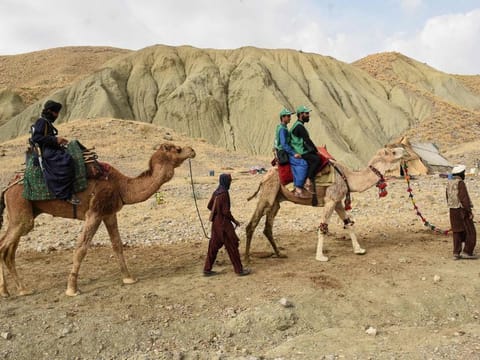 In this picture taken on March 23, 2023, a member of the levies tribal force (left) and census officials from the Pakistan Bureau of Statistics (right) ride camels to collect information from Marri tribespeople living in the remote mountainous area of Mawand as part of a national census in southwest Pakistans Kohlu district, Balochistan province.  