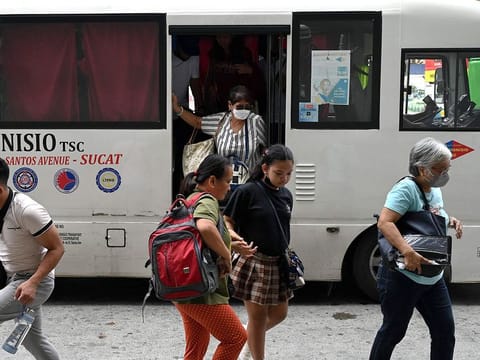 Passengers arrive at a bus terminal in Paranaque City, Metro Manila. 