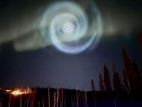 A light baby blue spiral resembling a galaxy appears amid the aurora for a few minutes in the Alaska skies near Fairbanks, Saturday, April 15, 2023.  