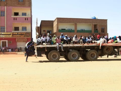 People fleeing street battle between the forces of two rival Sudanese generals, are transported on the back of a truck in the southern part of Khartoum, on April 21, 2023.  