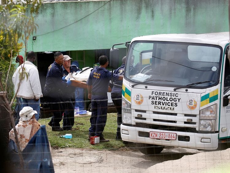 A body is moved at the scene of a deadly mass shooting near Pietermaritzburg