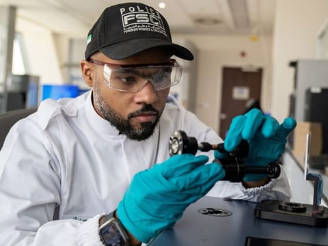 A Dubai Police forensics expert checks the ballistic fingerprint of an ammunition 