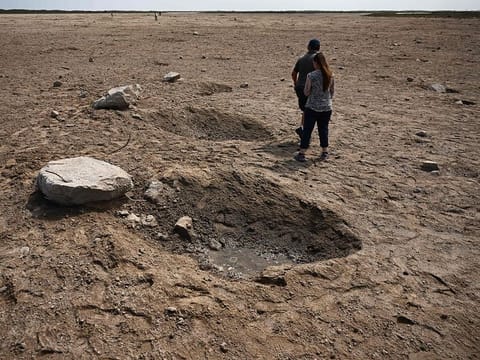 Members of the public walk through a debris field at the launch pad in Boca Chica, Texas