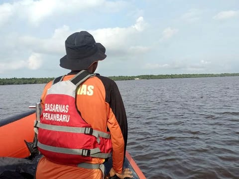 A rescuer scans the horizon during the search for victims of a sinking speedboat in Indragiri Hilir Regency, Indonesia. 