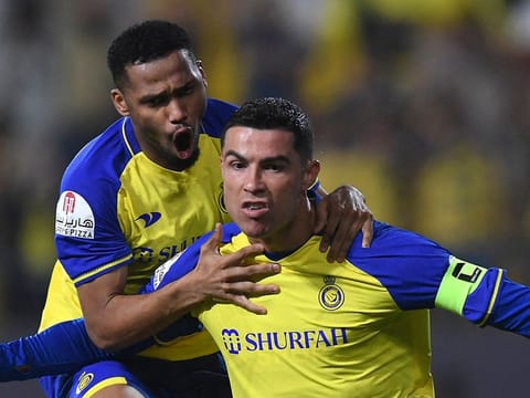 Nassr's Portuguese forward Cristiano Ronaldo (R) celebrates scoring his team's first goal during the Saudi Pro League football match between Al Nassr and Al Raed 