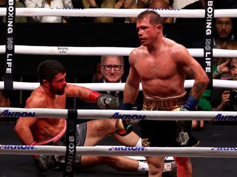 Canelo Alvarez (R) fights John Ryder (L) who falls to the mat during their boxing match for the WBA, WBC, IBF and WBO super middleweight titles at Akron Stadium in Guadalajara, Jalisco State, Mexico.
