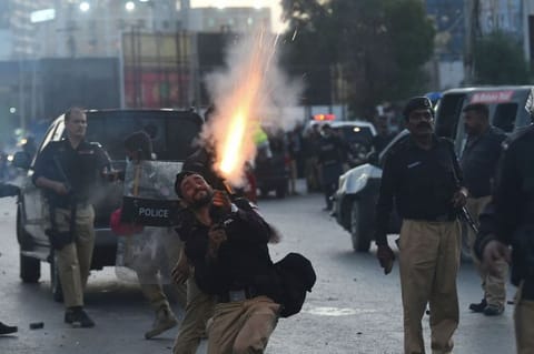 Police fire tear gas shells towards Pakistan Tehreek-e-Insaf (PTI) party activists and supporters of former Pakistan's Prime Minister Imran during a protest against the arrest of their leader, in Karachi on May 9, 2023.  