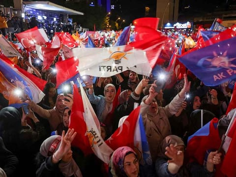 Supporters of Turkish President Tayyip Erdogan wave flags outside the AK Party headquarters, in Ankara, Turkey May 15, 2023. 