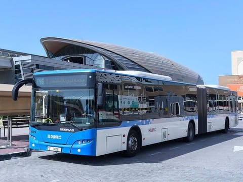 An RTA public bus next to a Dubai Metro station