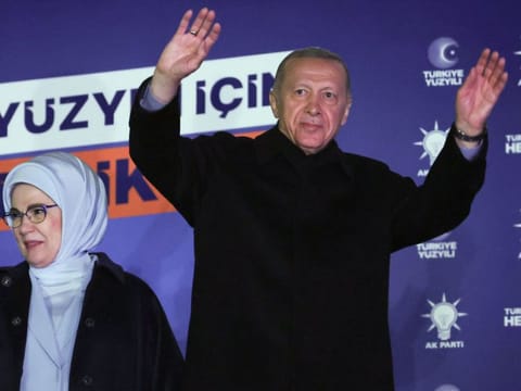 Turkish President Tayyip Erdogan, accompanied by his wife Ermine Erdogan, waves to supporters at the AK Party headquarters in Ankara, on May 15, 2023.  