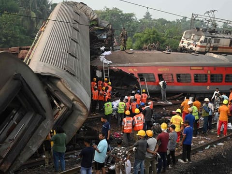 Rescue workers gather around damaged carriages at the accident site of a three-train collision near Balasore, about 200 km (125 miles) from the state capital Bhubaneswar in the eastern state of Odisha, on June 3, 2023.  