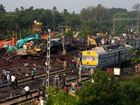 People watch the site where trains that derailed, in Balasore district, in the eastern Indian state of Orissa, Sunday, June 4, 2023.