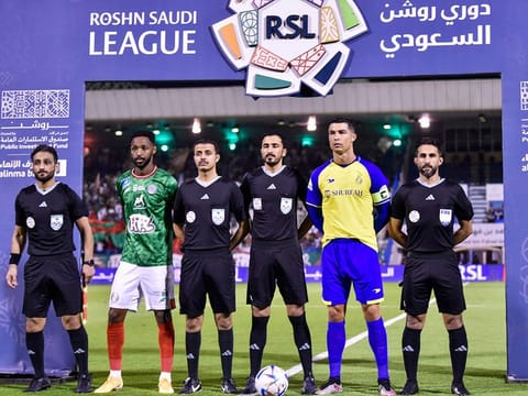 Nassr's Portuguese forward and team captain Cristiano Ronaldo (2nd R) and Ettifaq's Saudi midfielder and team captain Ali Hazazi (2nd L) pose for a picture with the referee team ahead of the Saudi Pro League football match between Al Nassr and Al Ettifaq at the Prince Mohammed Bin Fahd Stadium in Dammam on May 27, 2023. 