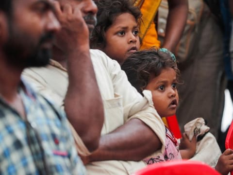 Children watch visuals of the deceased, displayed on a big screen after a multiple train collision in Balasore, at a hospital in Bhubaneswar in the eastern state of Odisha on  June 6, 2023.  
