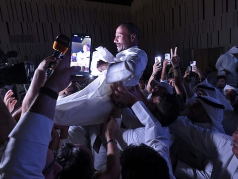 Kuwaiti candidate and former parliament speaker Marzouq Al Ghanim celebrates with his supporters following the announcement of his victory in legislative elections, in Kuwait city, on early June 7, 2023.  