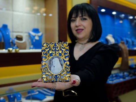 Maha Al Sibai holds up one of her latest works at her boutique store in Wafi Mall in Dubai. 