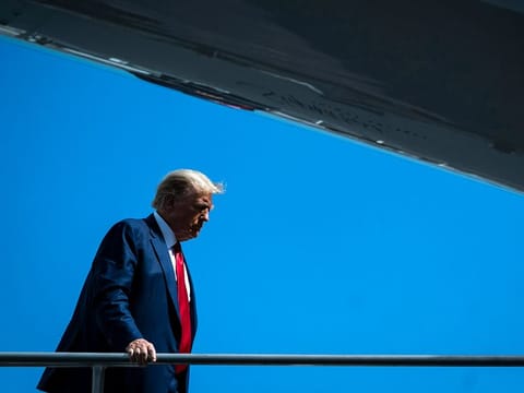 Former president Donald Trump boards his plane to fly back to New Jersey after pleading not guilty to federal charges on Tuesday in Miami. 