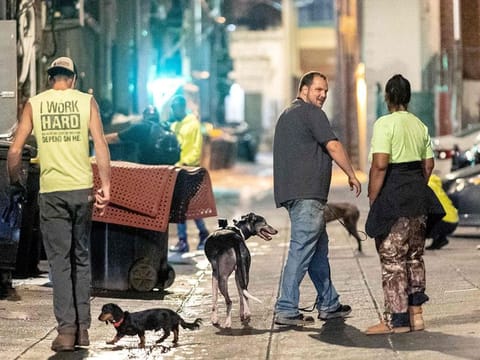 A group of rat hunters search for rats while walking down an alleyway in the Adams Morgan neighborhood of Washington, DC