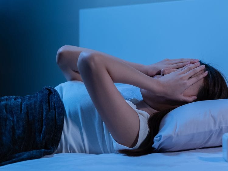 person lying awake and stressed