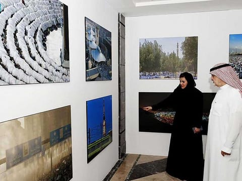 Saudi officials inspect photos on display at the “Pilgrim’s Journey” exhibit. 