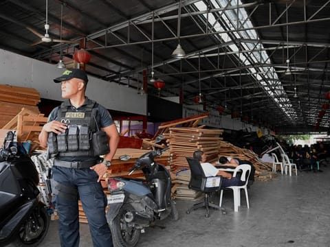 A policeman stands guard inside a compound, where police raided buildings in Metro Manila on June 27, 2023. 