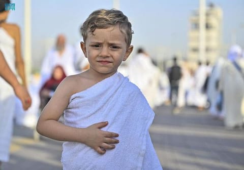 A child attends Hajj alongside his parents. 