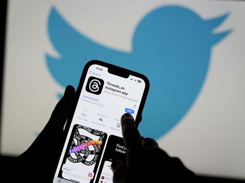 The Threads app, operated by Meta Platforms Inc., on a smartphone, besides a Twitter Inc. logo, arranged in Madrid, Spain, on Tuesday, July 5, 2023. Threads is a “text-based conversation app” that’s widely seen as an alternative to Twitter. 
