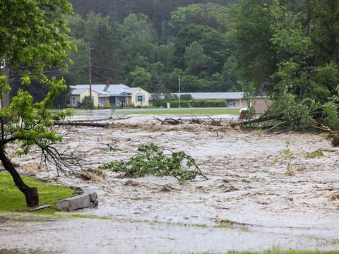 Water floods around homes as the river overflows along Route 11 on July 10, 2023 in Windham, Vermont.   