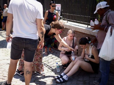 A tourist from the UK receives help near the Colosseum after fainting during a heatwave across Italy, in Rome, Italy July 11, 2023.  