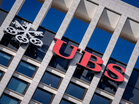 FILE - The logo of Swiss bank UBS is fixed on a building where the bank has offices in Frankfurt, Germany, Nov. 8, 2022. Swiss banking giant UBS will pay nearly $400 million in fines to U.S., Swiss and U.K. banking authorities for the management failures of Credit Suisse, which UBS bought in June 2023, related to how Credit Suisse handled its relationship with collapsed hedge fund Archegos Capital Management. (AP Photo/Michael Probst, File)